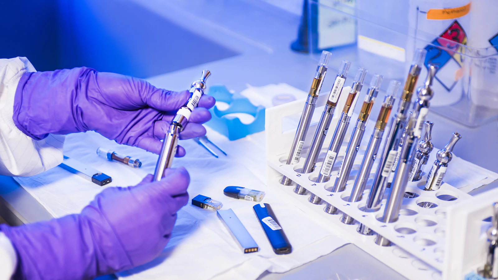 A laboratory worker holds a tube containing a blood sample.
