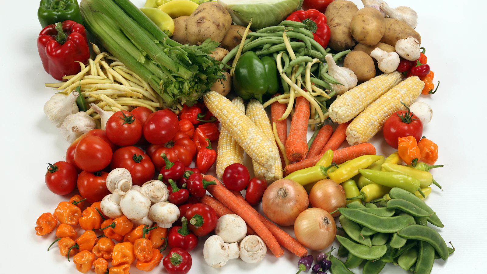 Fresh vegetables in many colours on a light surface.